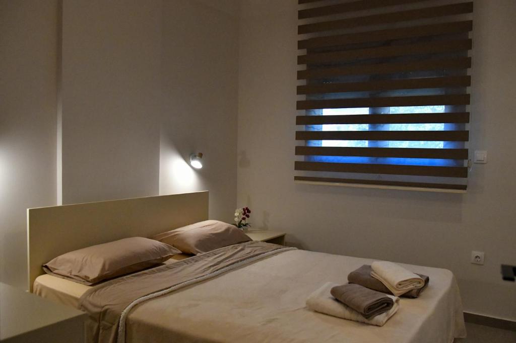 a bedroom with a bed with two pillows and a window at Everlong Boutique Home in Nea Michaniona