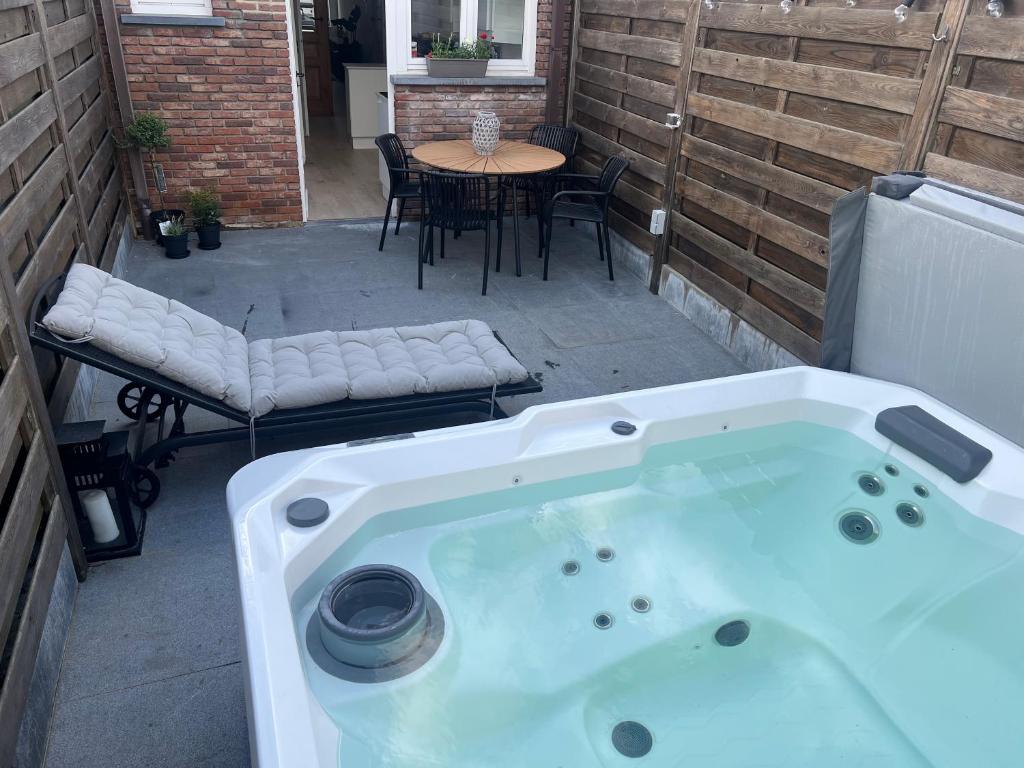 a hot tub on a patio with a table and chairs at Holiday house with private jaccuzi - Leuven city center in Leuven