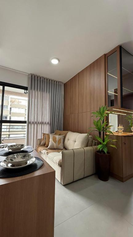 a living room with a couch and a table at Studio moderno, rooftop com piscina, próx UFU in Uberlândia