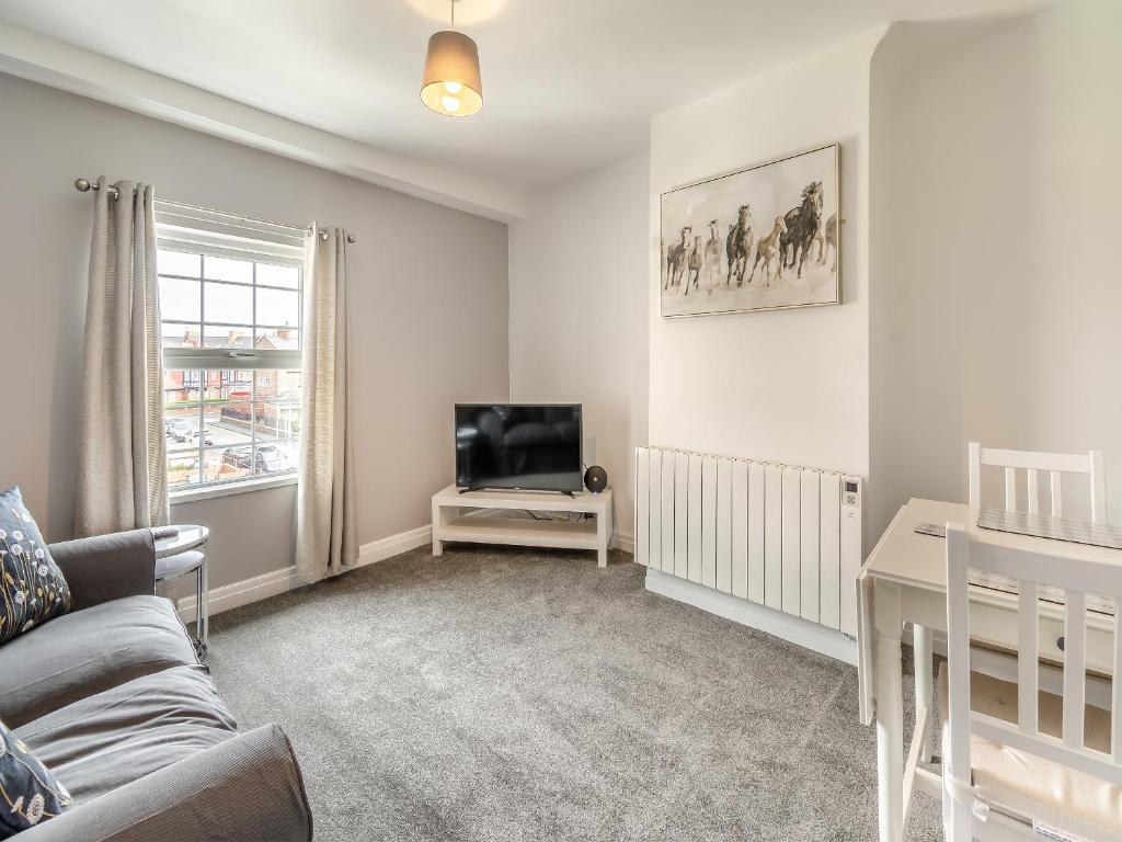 a living room with a couch and a tv at Bluebell Apartment - Uk42381 in Bridlington