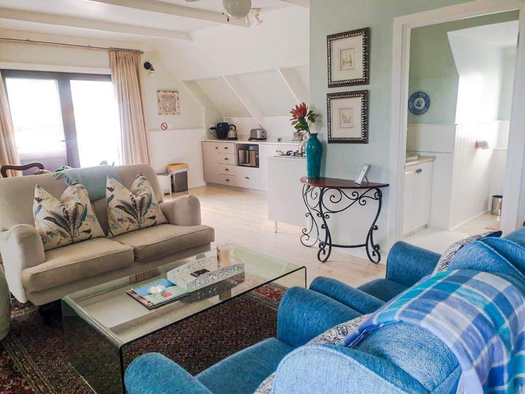 a living room with a couch and a table at Turquoise Loft, Noordhoek, Cape Town in Good Hope