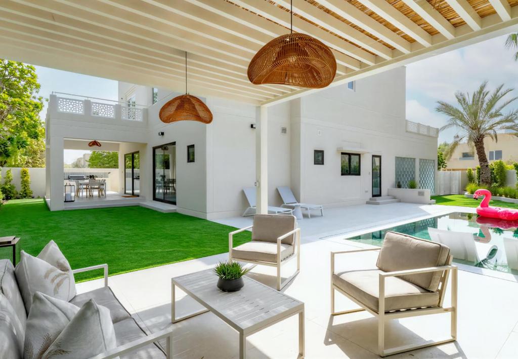 an outdoor living room with a pool and a patio at Villa Mansour in Abu Dhabi