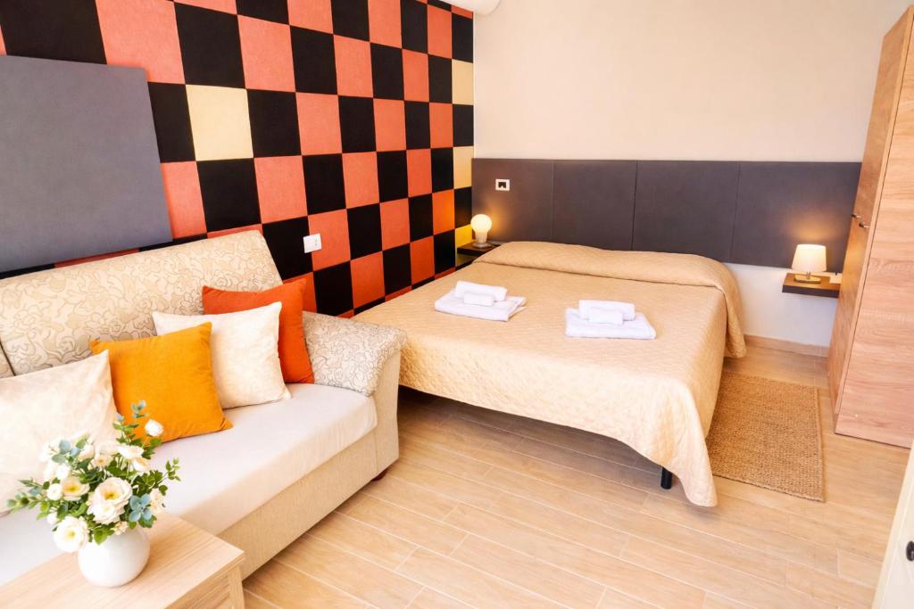 a small room with two beds and a couch at Vicino Aeroporto - Orange Marina Room in Olbia
