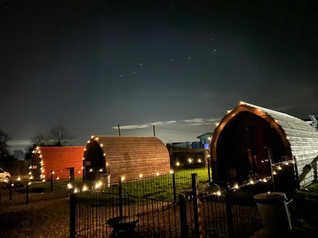 a couple of yurtages with lights in the dark at Poplars Farm Site Glamping Pods Adults only with separate, private shower rooms in Hulland