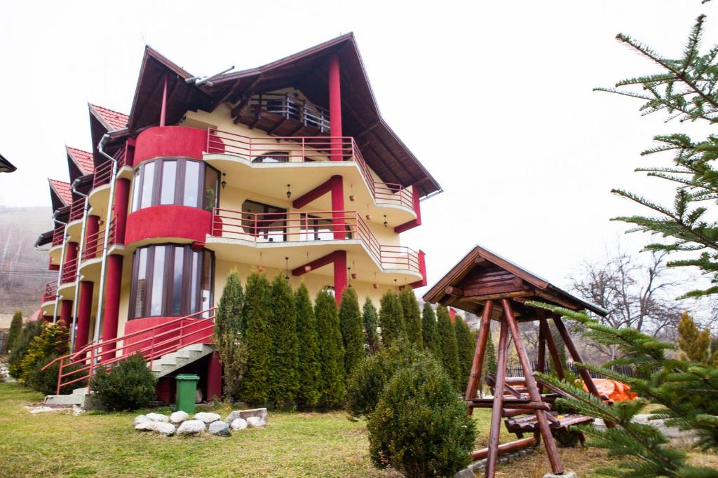 a house on a hill with trees in front of it at Casa Nobilă in Bran