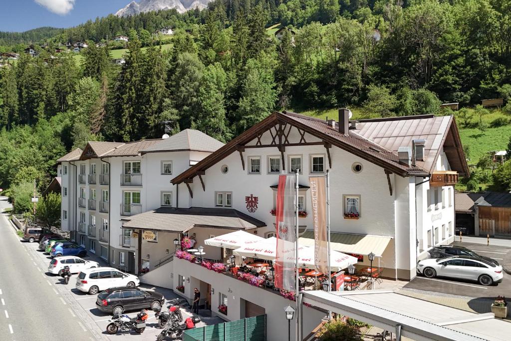 Luftaufnahme eines Hotels mit auf einem Parkplatz geparkten Autos in der Unterkunft Posthotel Strengen am Arlberg in Strengen