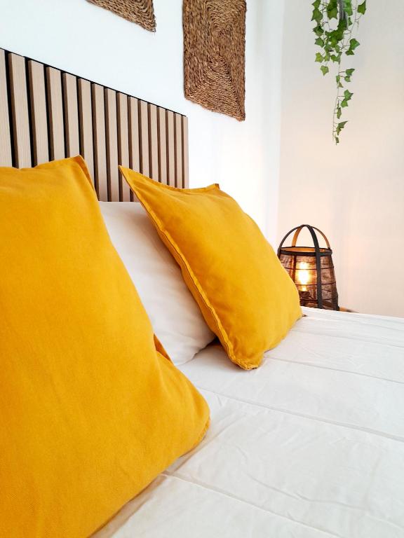a bed with two yellow pillows on it at Easy4Stay in Portimão