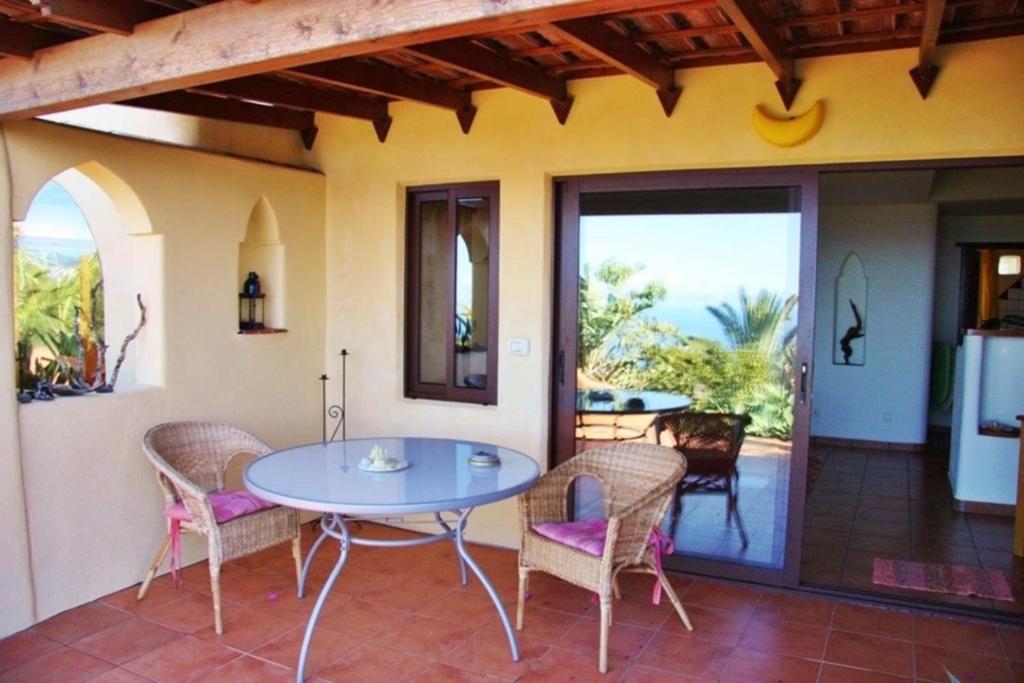 a dining room with a table and chairs on a patio at Casa Estrella, Ferienhaus in Las Manchas in Las Manchas