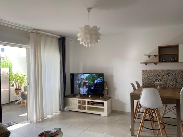 a living room with a tv and a table and a dining room at la mer la corse in San-Nicolao
