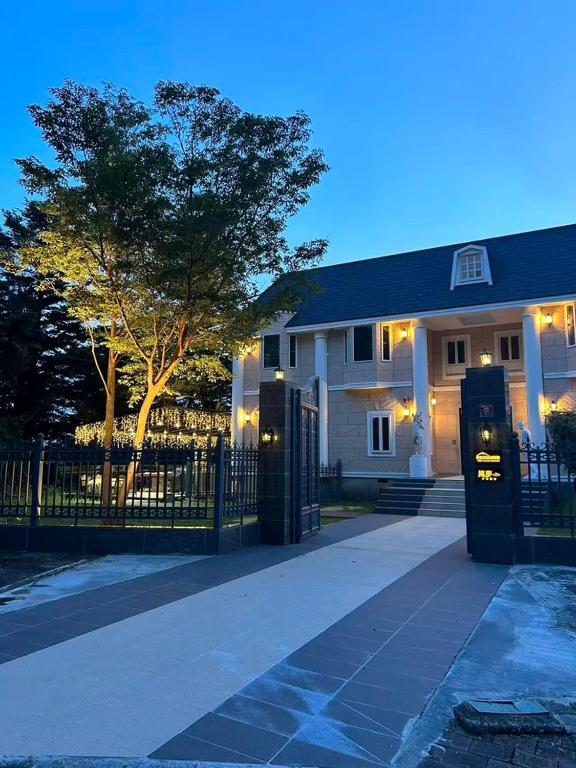 a house with a fence and a tree in front of it at Izu Plateau House 420 square meters, BBQ , 8 bedrooms, 1 living room 1kitchen 6 toilets 4 bathroom 1 onsen in Yawatano