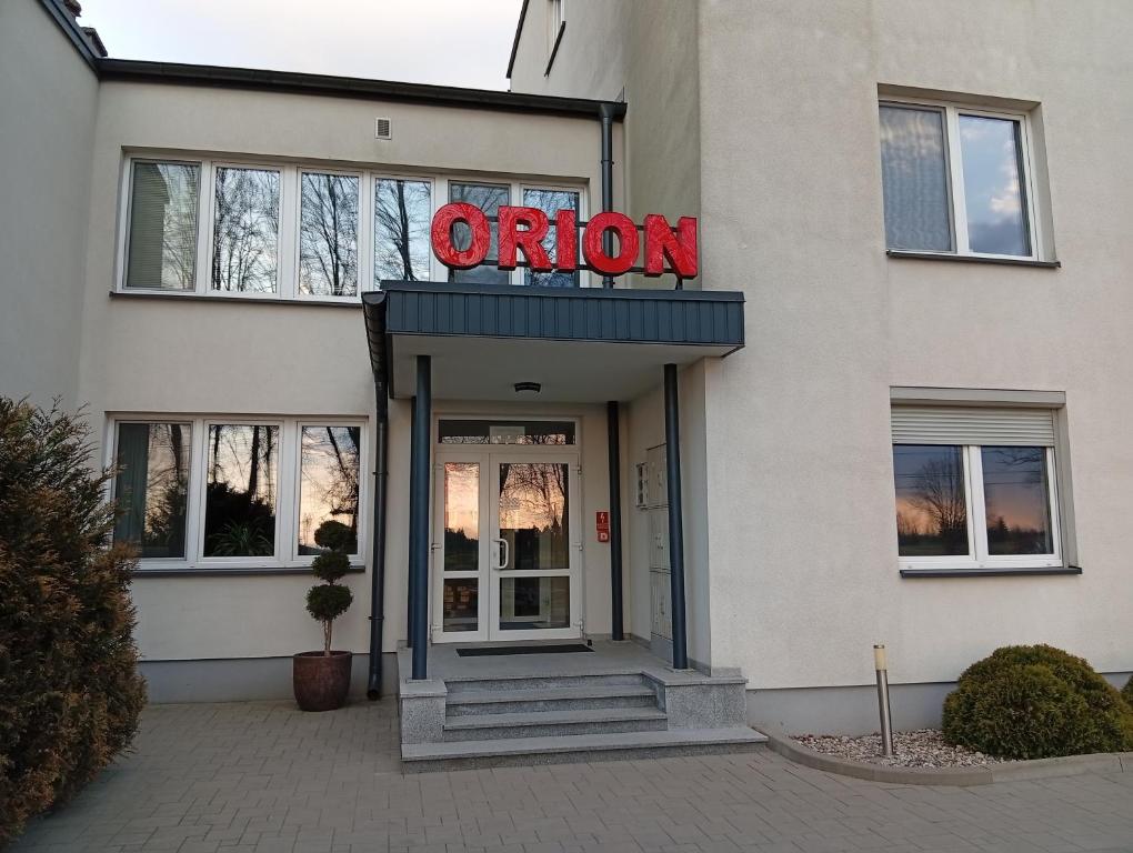 a entrance to a office building with a neon sign at ORION in Ostrów Mazowiecka
