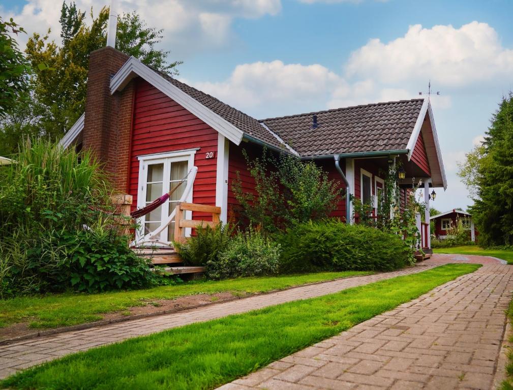 a red house with a brick driveway at Ferienhaus Sjö Hus Pülsen - Köhn in KÃ¶hn