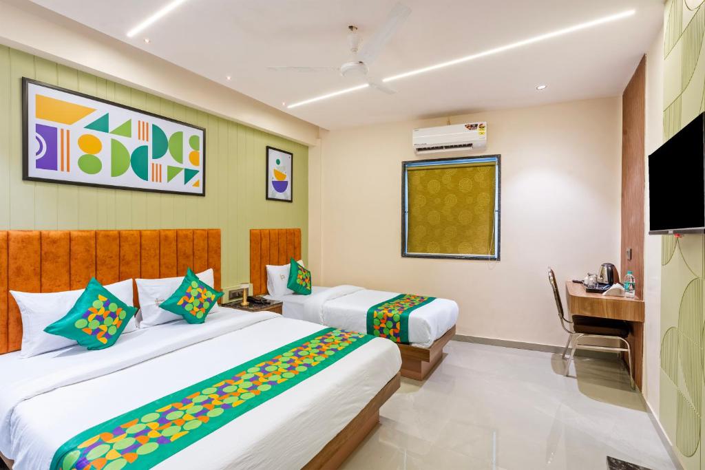 a hotel room with two beds and a television at Treebo Gateway Mansion in Mumbai