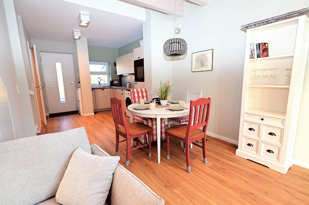 a dining room and living room with a table and chairs at Residenz R1 App 2 in Behrensdorf