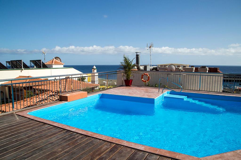 a large blue swimming pool on top of a building at Apartamentos Tapahuga in Playa de Santiago