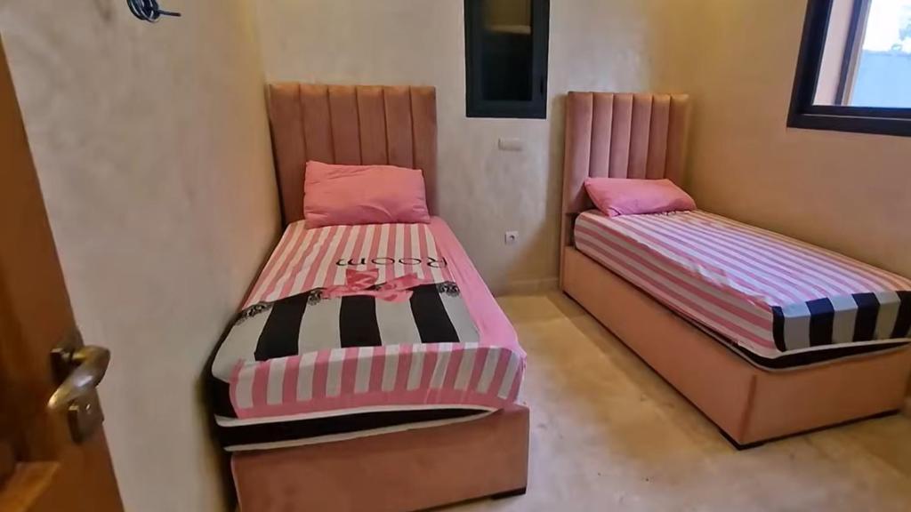 two beds sitting next to each other in a room at Prestige Villa in Marrakesh