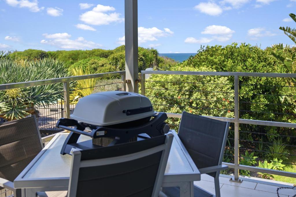 ein Helm, der auf einem Tisch auf einem Balkon steht in der Unterkunft Beachfront Family Apt - Ocean Views in Diamond Beach
