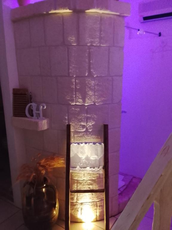 a room with a brick wall with purple lights at Dimora Bianca Ostuni in Ostuni