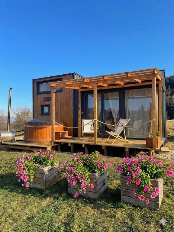 a tiny house with flowers in front of it at Domek w górach Tiny House Forest Jacuzzi/widoki in Lipnica Wielka