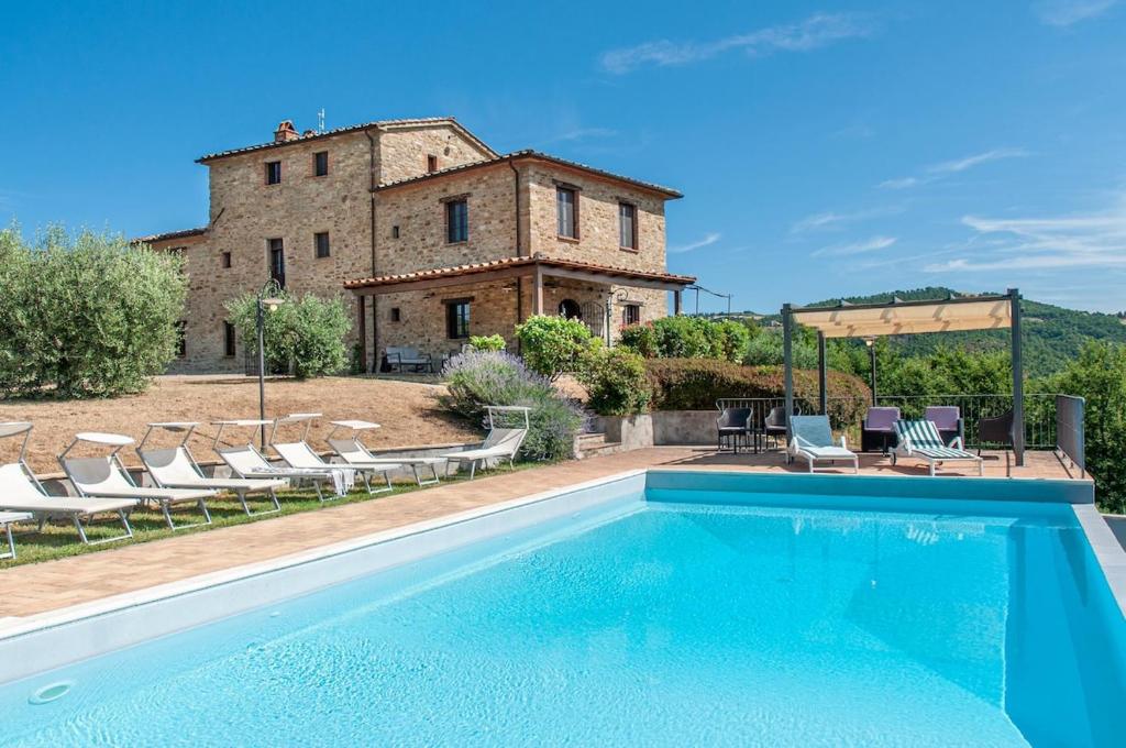 an outdoor swimming pool in front of a building at Villa Badia, large villa in Umbria with private pool in Città di Castello