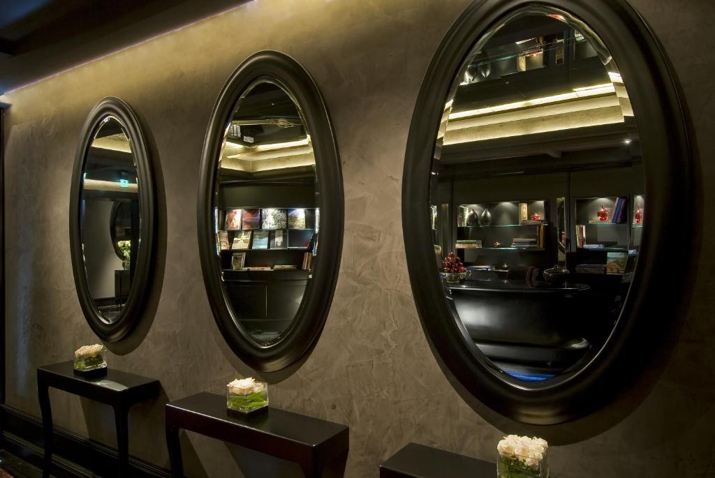 two mirrors on the wall of a restaurant with two tables at Hotel Palazzo Barbarigo Sul Canal Grande in Venice