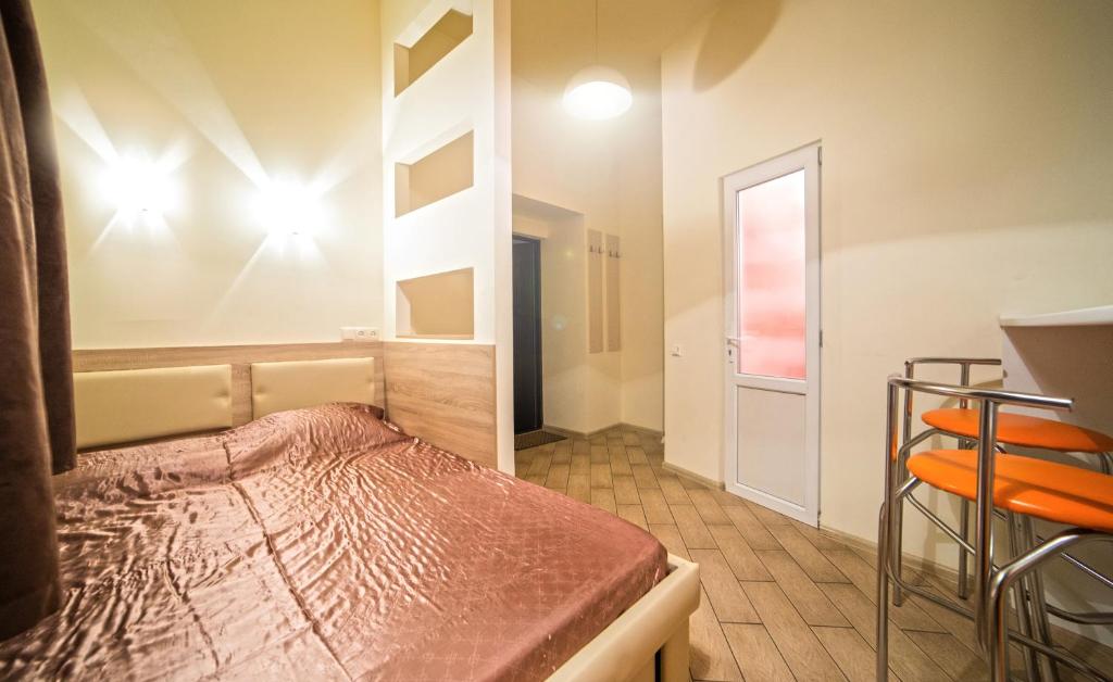 een kleine kamer met een bed en een deur bij Mini Apartment on Rappoporta 7a-3 in Lviv