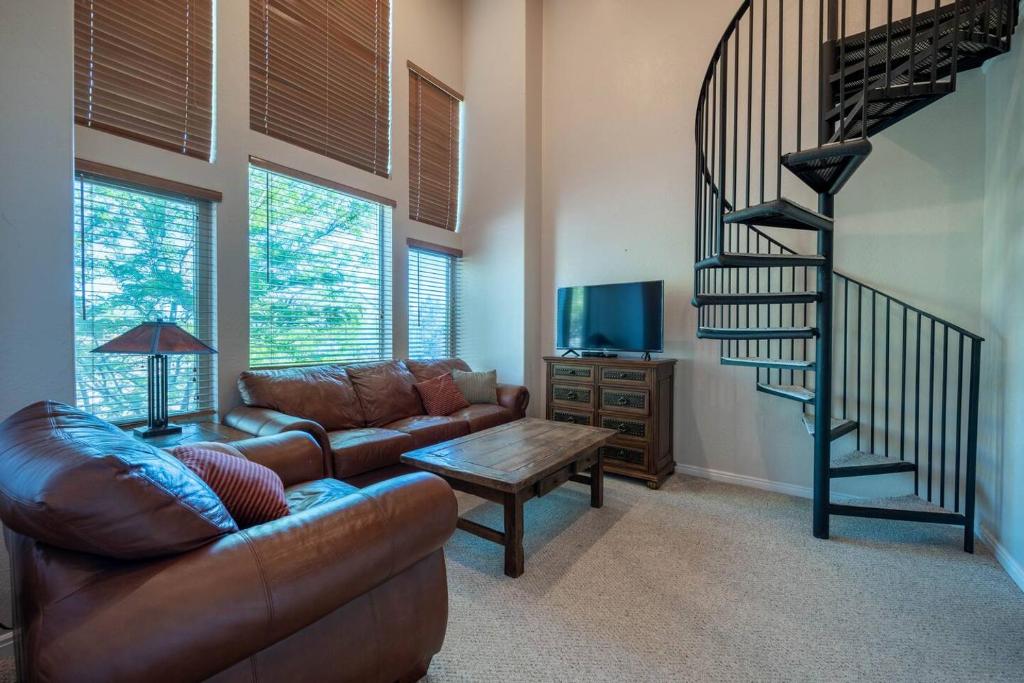 a living room with a couch and a spiral staircase at Bigfoots Alpine Retreat MH710By Powder Mtn Hot Tub in Eden