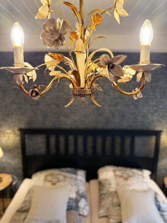 a chandelier with flowers in a room with a bed at Ferienwohnung Mona Lisa in Malterdingen
