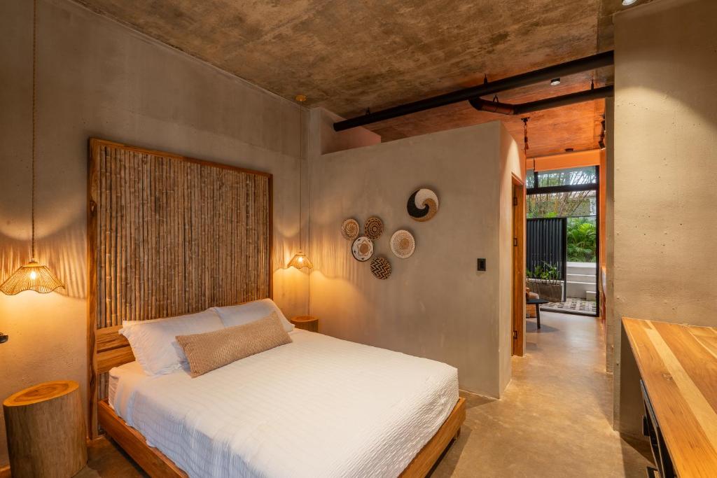 a bedroom with a white bed in a room at The Surfer's Base in Jacó
