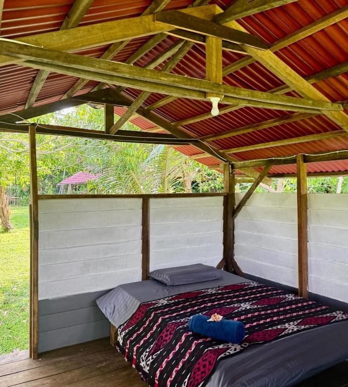 a bed in a tent with a wooden roof at The Ridge Surf Lodge in Biha