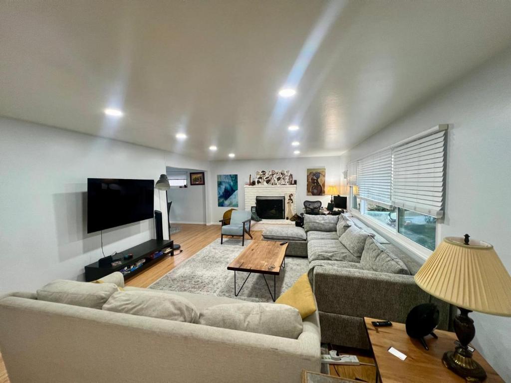 a living room with couches and a flat screen tv at Malcolm Commons in Oakland