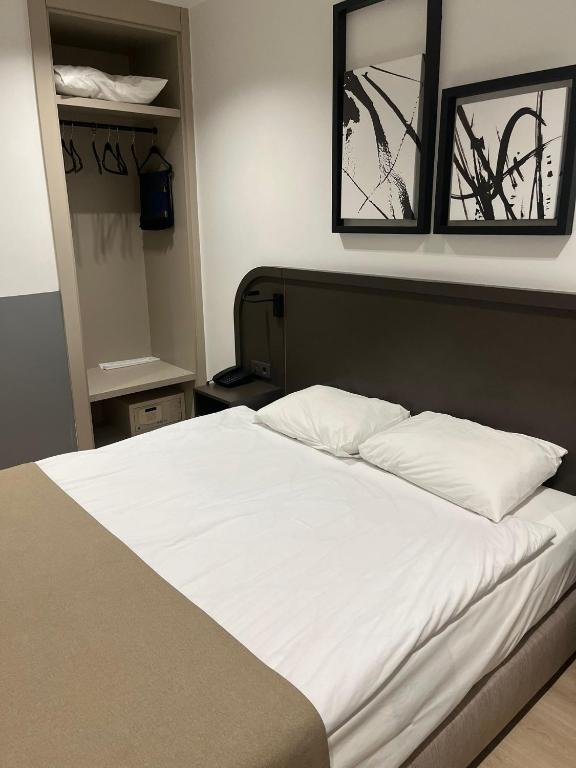 ein Bett mit weißen Laken und zwei Spiegeln darüber in der Unterkunft PARK DEMİRKAPI HOTEL in Beysehir
