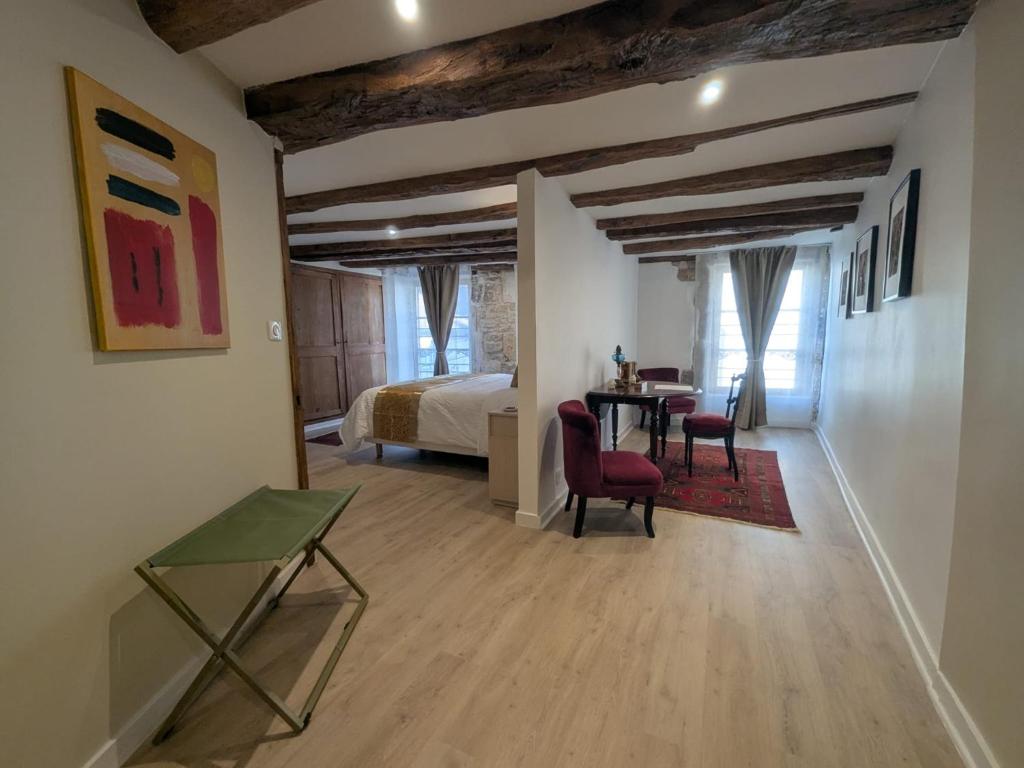 a room with a table and chairs and a bed at La demeure Langroise in Langres