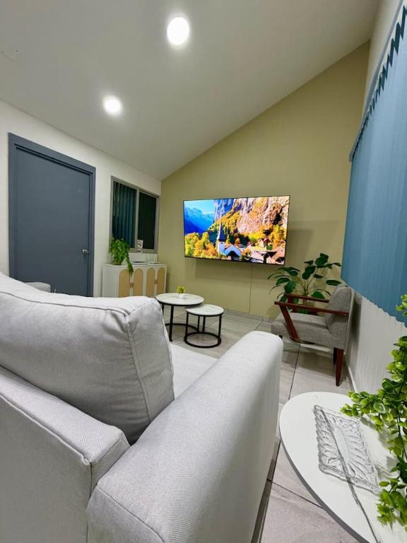 a living room with a couch and a tv on the wall at AR Suites 1 Centro de la ciudad in Zamora de Hidalgo