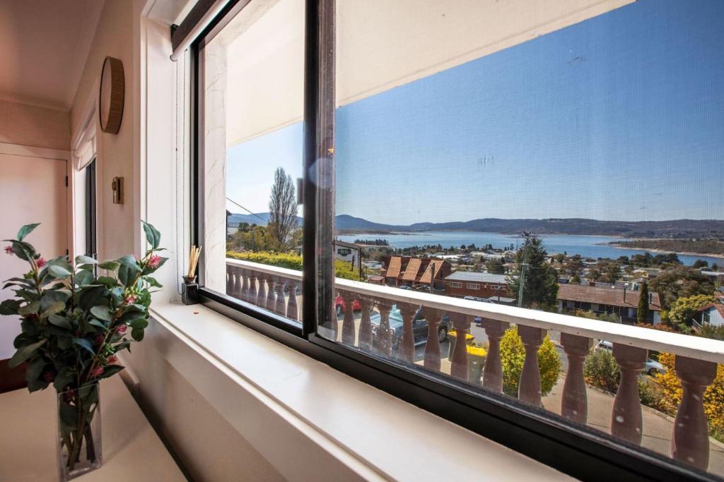 a window with a view of the water at Stunning Water Views 2 in Jindabyne