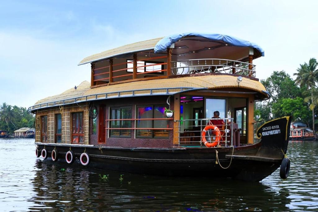 a house boat floating on the water at Sacred River Houseboats in Alleppey