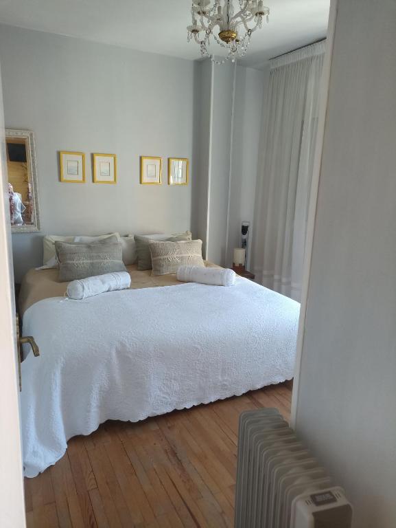 a white bedroom with a large bed with white sheets at apartamento céntrico zona Marques de comillas 8 in Laredo