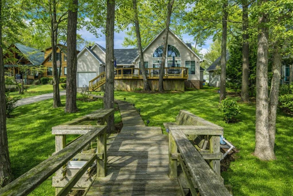 a home with two benches in front of a house at Lakefront Retreat-Sunset Views in Prosperity