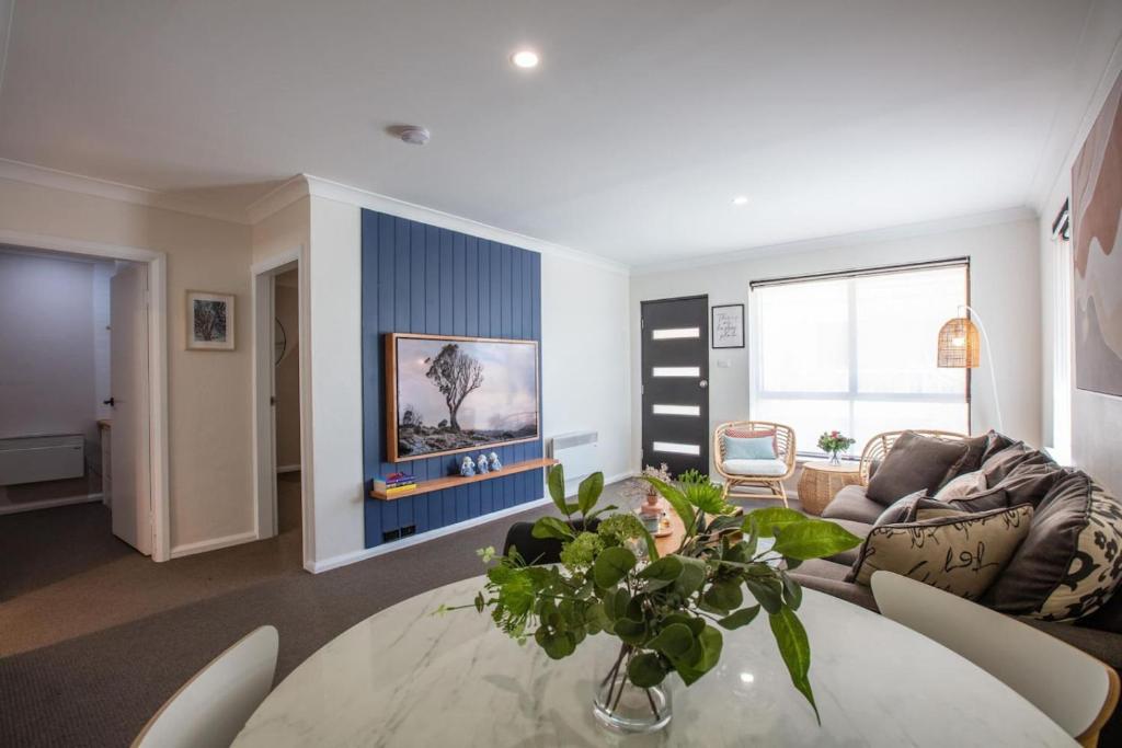 a living room with a table and a couch at Mountain Oak 2 Jindabyne in Jindabyne