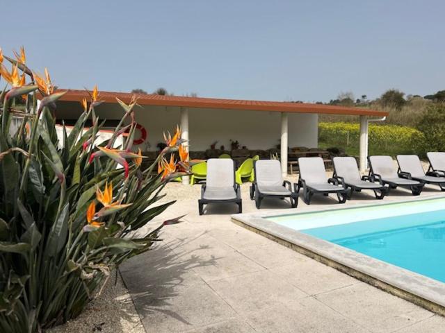 a swimming pool with lounge chairs next to a swimming pool at VillaVie CostadePrata in Alfeizerão