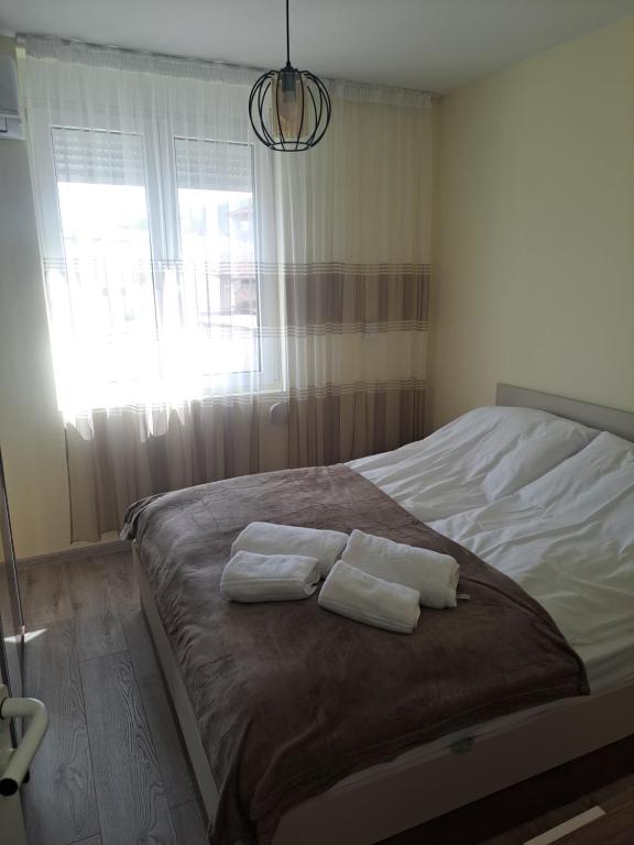 a bedroom with a bed with two towels on it at Удобство - 3 in Petrich