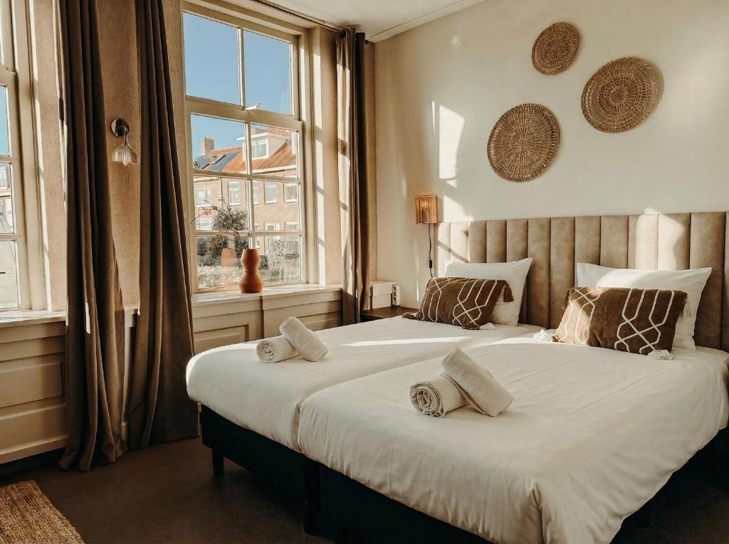 a bedroom with two beds and a window at Multi-bedroom stay 9 Rooms near Beach in Zoutelande