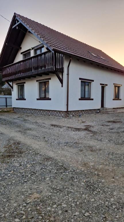 a white house with windows and a roof at Cabana Angela in Râșca