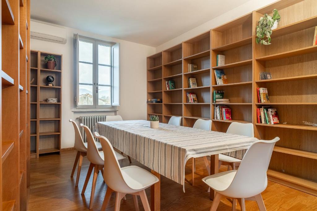 a dining room with a table and chairs and bookshelves at Chica's Lucca Luxury Loft in Lucca