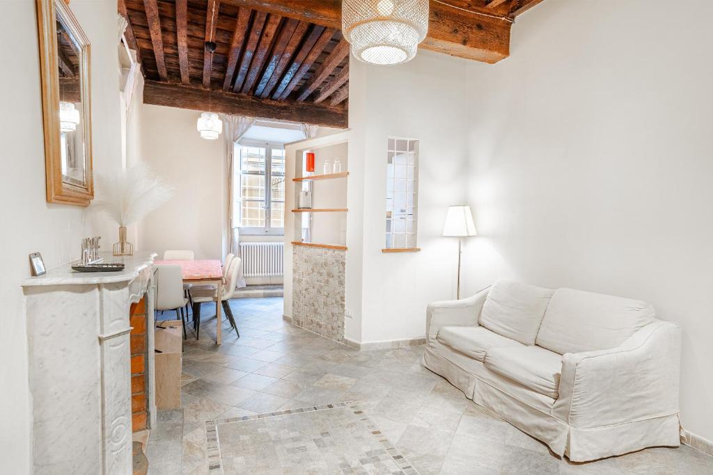 a living room with a white couch and a table at Appartamento La Naiade, Lucca in Lucca