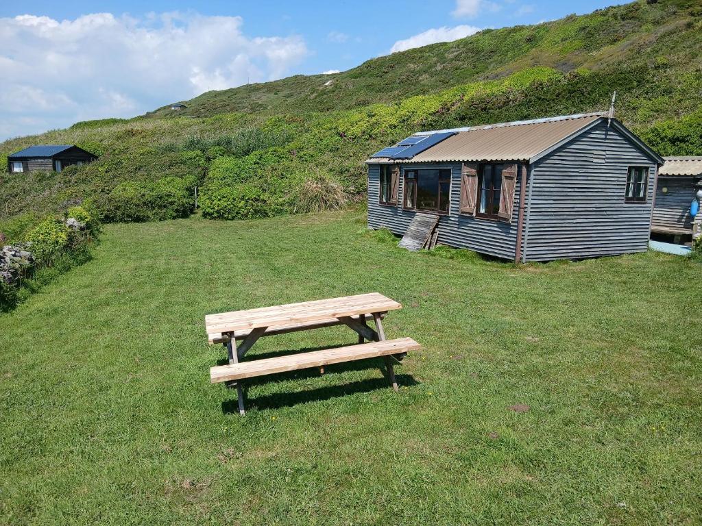 a picnic table in a field next to a house at The Cabin in Cawsand