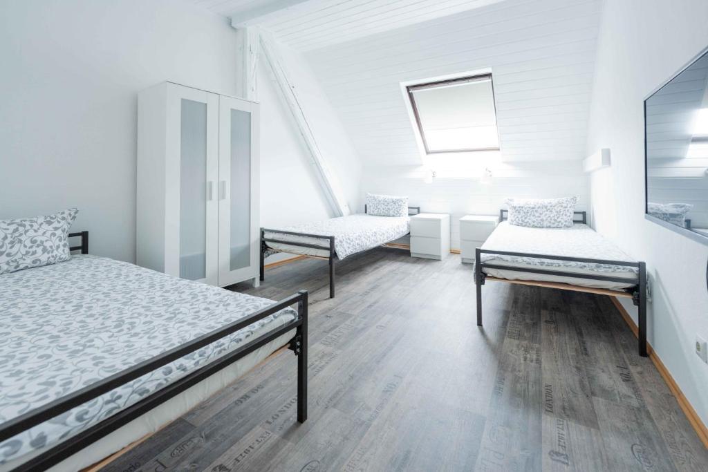 a white room with two beds and a mirror at FREYZEIT Apartment "Gässel" in der Altstadt von Speyer für bis zu 6 Personen in Speyer