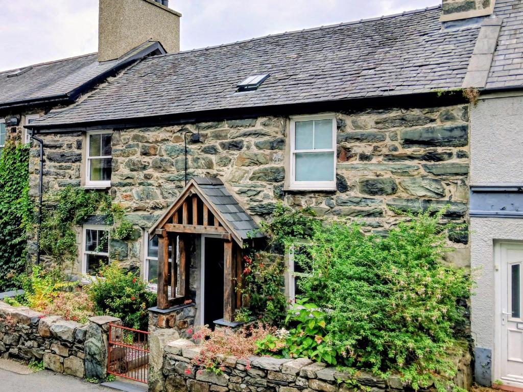 an old stone house with a gambrel roof at Gerlan in Harlech