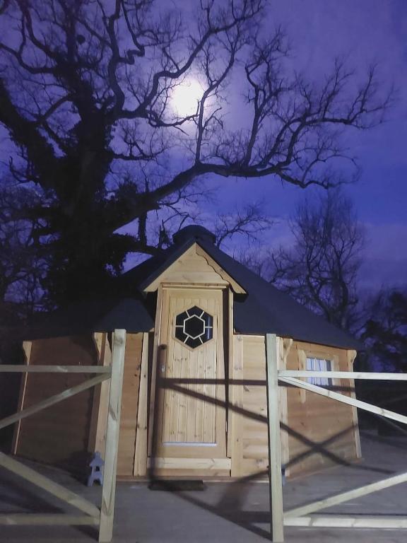 a wooden dog house at night with a full moon at Auvergne Kota in Brugheas