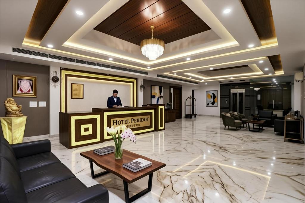 a lobby of a hotel with a man standing behind a podium at Hotel Peridot with Free Airport Pickup in New Delhi